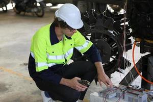 ingegnere che controlla il pannello di controllo e insegna il nuovo braccio robotico automatico e la macchina di controllo operativa in fabbrica. foto