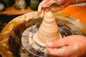 vasaio che lavora al tornio del vasaio con l'argilla. processo di produzione di stoviglie in ceramica nel laboratorio di ceramica. foto