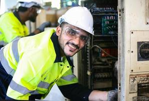 gli ingegneri della manutenzione stanno lavorando davanti alla riparazione automatizzata dei macchinari cnc su una lista di controllo di manutenzione sulla linea di produzione. foto