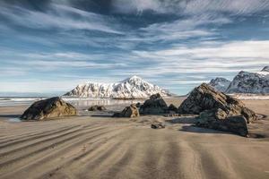 solco naturale di sabbia con montagna di neve e cielo blu sulla spiaggia di skagsanden foto