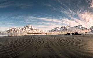 panorama della catena montuosa della neve con solchi di sabbia sulla costa alla spiaggia di skagsanden foto