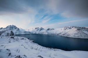 alba sul picco innevato di segla sull'isola di senja in inverno foto