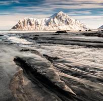 paesaggio marino di solchi sabbia con neve montagna e cielo blu nell'Oceano Artico al mattino di alba