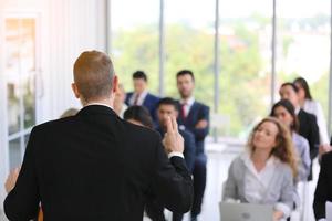 relatore che fa una presentazione in sala. udienza o sala conferenze. vista posteriore di partecipanti non riconosciuti in pubblico. evento convegno scientifico, formazione foto