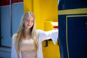 ritratto di una bella giovane donna bionda in piedi in treno. foto