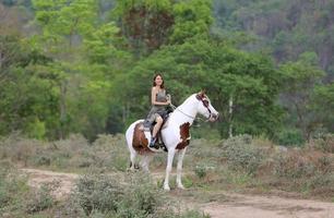 giovane donna con il suo cavallo nella luce del tramonto di sera. fotografia all'aperto con ragazza modella. umore dello stile di vita foto