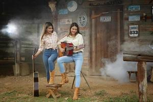 modello di cowgirl in posa in fattoria. un ritratto di una giovane e bella cowgirl appoggiata a un muro in una stalla in fattoria. foto