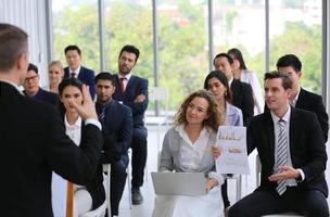 relatore che fa una presentazione in sala. udienza o sala conferenze. vista posteriore di partecipanti non riconosciuti in pubblico. evento convegno scientifico, formazione foto