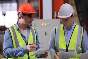 il caposquadra o il lavoratore del settore lavora presso il sito di fabbrica controlla la macchina o i prodotti in loco. ingegnere o tecnico che controlla materiale o macchina sull'impianto. industriale e di fabbrica. foto