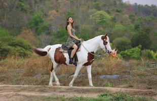 giovane donna con il suo cavallo nella luce del tramonto di sera. fotografia all'aperto con ragazza modella. umore dello stile di vita foto