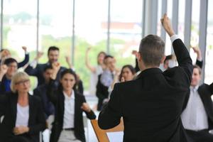 relatore che fa una presentazione in sala. udienza o sala conferenze. vista posteriore di partecipanti non riconosciuti in pubblico. evento convegno scientifico, formazione foto