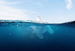 sacchetti di plastica che galleggiano nel mare blu e nell'inquinamento del mare foto