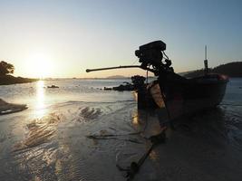 barca da pesca sulla spiaggia al tramonto a Koh Lipe foto