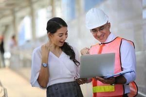 l'ingegnere e la donna d'affari che controllano gli appunti al cantiere edile. il concetto di ingegneria, costruzione, vita cittadina e futuro. foto