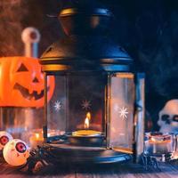concetto di vacanza di Halloween di zucca, candele, decorazioni spettrali con fumo di tono blu intorno su un tavolo di legno scuro, primo piano. foto