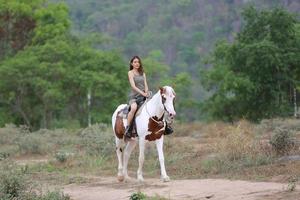 giovane donna con il suo cavallo nella luce del tramonto di sera. fotografia all'aperto con ragazza modella. umore dello stile di vita foto