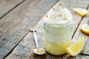 dessert a strati con crema al limone, gelato e panna montata foto
