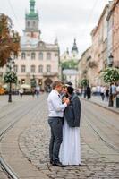 servizio fotografico di matrimonio sullo sfondo del vecchio edificio. lo sposo guarda la sua sposa in posa. fotografia di matrimonio rustica o boho. foto