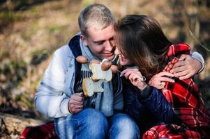 due giovani backpackers accovacciati su un cumulo di neve e parlando mentre si scaldano le mani sul fuoco foto