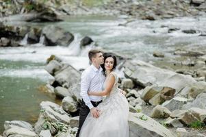 sposa e sposo. cerimonia di matrimonio vicino a un fiume di montagna foto