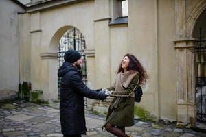 coppia di innamorati che si divertono all'aperto. uomo che copre gli occhi della donna con cappuccio. foto