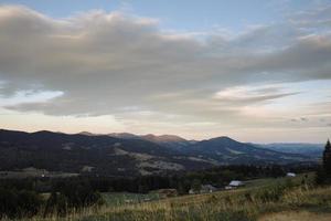 maestoso faggio solitario su un pendio collinare con travi soleggiate a valle di montagna. drammatica scena mattutina colorata. foglie autunnali rosse e gialle. carpazi, ucraina, europa. mondo della bellezza. foto