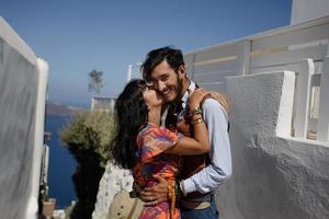 giovane coppia felice uomo e donna in una chiesa greca a oia thira cyalides santorini in grecia foto