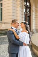 servizio fotografico di matrimonio sullo sfondo del vecchio edificio. lo sposo guarda la sua sposa in posa. fotografia di matrimonio rustica o boho. foto