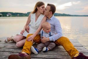 padre e madre guidano per mano il figlio di un anno. foto