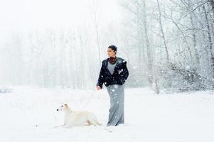 passeggiata invernale in una tempesta di neve con un cane foto