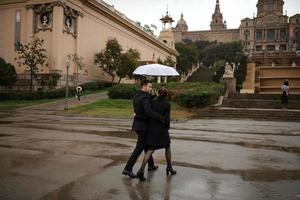 giovane bella coppia ispanica amorevole cammina sotto un ombrello durante la pioggia. foto