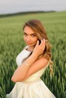 sposi in un campo di grano. la coppia si abbraccia durante il tramonto foto