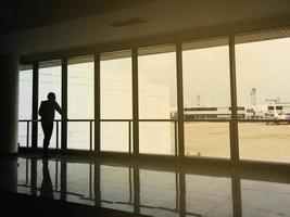 uomo in attesa di aereo nel terminal, silhouette foto