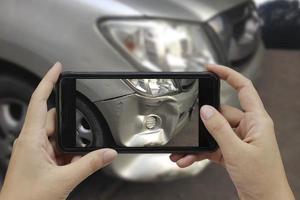 mano che tiene lo smartphone scatta una foto sulla scena di un incidente d'auto, incidente d'auto per l'assicurazione