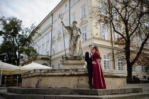 ritratto di bella coppia sorridente di amore seduta vicino alla fontana all'aperto in città. bel giovane e donna. foto