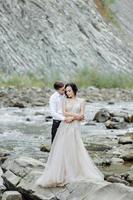 sposa e sposo. cerimonia di matrimonio vicino a un fiume di montagna foto