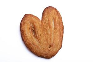 pane cotto a forma di cuore, pasta sfoglia da forno su sfondo bianco. foto