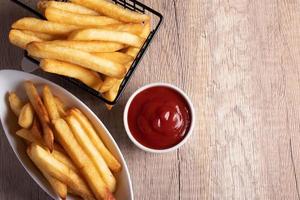 patatine fritte in un cestino nero con salsa di pomodoro foto