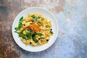 tagliatelle fritte con salsiccia di maiale alla griglia vietnamita, uova e foglie di gnemon gnetum foto