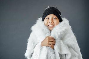 ragazzo carino che indossa abiti invernali sentendo freddo durante la stagione invernale foto