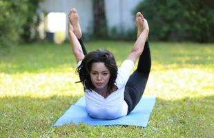 giovane donna di razza mista distesa sulla schiena sul compagno di yoga. foto