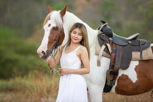 giovane donna con il suo cavallo nella luce del tramonto di sera. fotografia all'aperto con ragazza modella. umore dello stile di vita foto