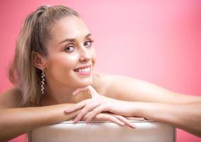 ritratto di giovane donna sorridente con cura della pelle sanitaria su sfondo rosa foto