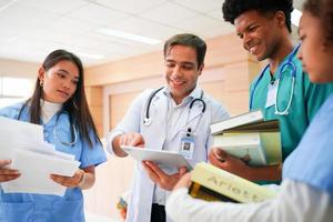 equipe medica internazionale. personale medico ospedaliero. incontro medico e infermiere asiatico e caucasico di razza mista. clinica e stetoscopio. foto