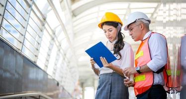 l'ingegnere e la donna d'affari che controllano gli appunti al cantiere edile. il concetto di ingegneria, costruzione, vita cittadina e futuro. foto