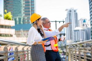 l'ingegnere e la donna d'affari che controllano gli appunti al cantiere edile. il concetto di ingegneria, costruzione, vita cittadina e futuro. foto