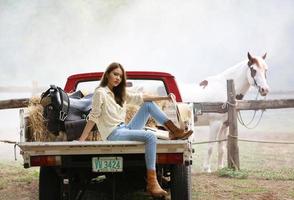 giovane donna con il suo cavallo nella luce del tramonto di sera. fotografia all'aperto con ragazza modella. umore dello stile di vita foto