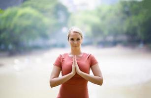 per tutta la lunghezza della donna che esercita yoga sulla stuoia al parco foto