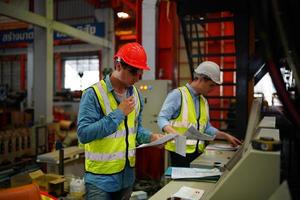 ingegnere industriale maschile che indossa un casco di sicurezza mentre si trova in una fabbrica industriale pesante. la manutenzione cercando di lavorare su macchinari industriali e controllare l'installazione del sistema di sicurezza in fabbrica. foto