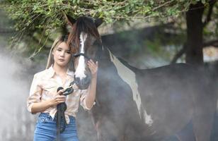 giovane donna con il suo cavallo nella luce del tramonto di sera. fotografia all'aperto con ragazza modella. umore dello stile di vita foto